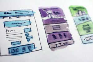dessin à la main de trois mockup de page web de couleur bleue, violette et verte
